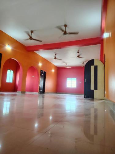Una habitación vacía con paredes rojas y naranjas y una puerta. en Hotel Saksham, en Pākaur