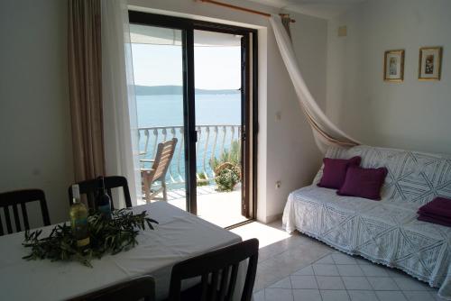 a living room with a table and a view of the ocean at Apartmani Braco Caratan in Zavala