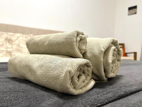 uma pilha de toalhas em cima de uma cama em Tilahome - Malpensa Apartment em Somma Lombardo