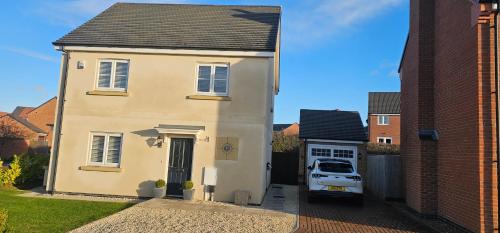 Hart's Place في Broughton Astley: سيارة فان بيضاء متوقفة أمام منزل