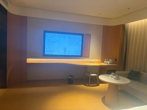 Zimmer mit einem Schreibtisch und einem Computermonitor an der Wand in der Unterkunft JI Hotel Nanjing Qinhuai Baixia High-tech Industrial Park in Nanjing