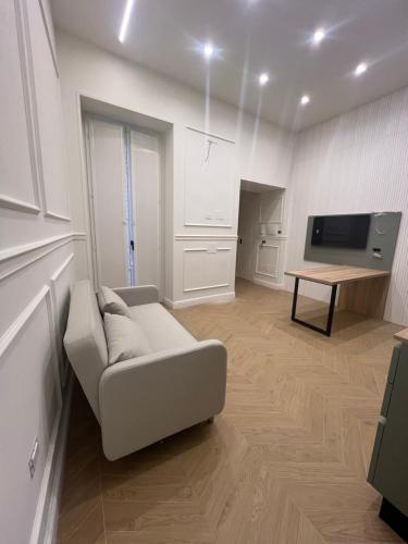 extra luxury apartment salerno center في ساليرنو: غرفة معيشة بيضاء مع أريكة وتلفزيون