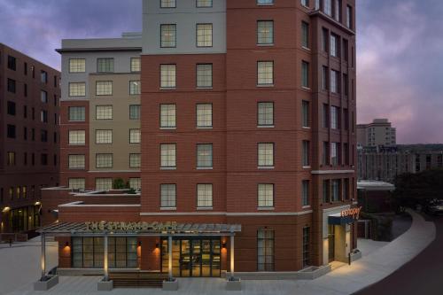 a tall red brick building next to a building at Canopy By Hilton Ithaca Downtown in Ithaca