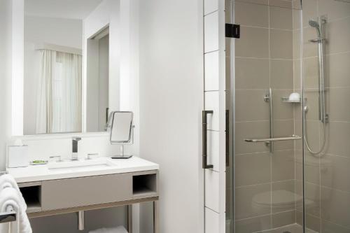 a bathroom with a sink and a shower at Canopy By Hilton Ithaca Downtown in Ithaca
