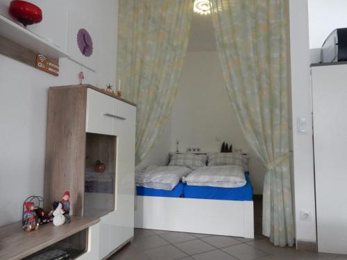 a small bedroom with a bed with a curtain at Spitzenkemenate in Burgneudorf