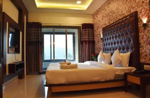 um quarto com uma cama grande e uma janela grande em Krushnai Resort em Kharakvasla