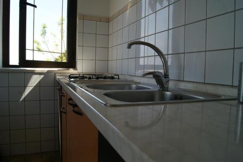 a kitchen with a sink and a window at Apartmani Braco Caratan in Zavala