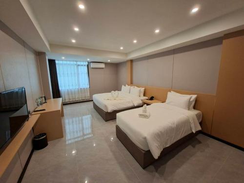 een hotelkamer met twee bedden en een flatscreen-tv bij Velin Pattaya Hotel in Ban Nong Chaeng