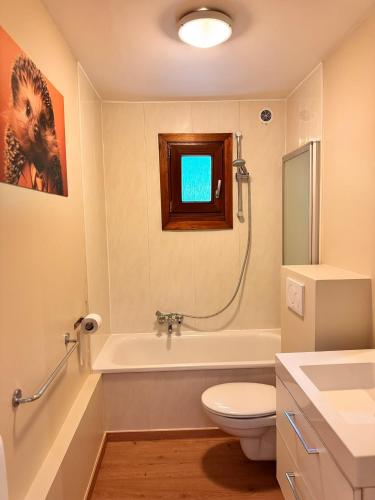 a bathroom with a toilet and a tub and a sink at Orée du Bois in Petit Mesnil