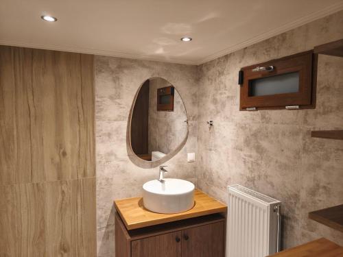 un bagno con lavandino e specchio di Feggaropetra a Kalívia