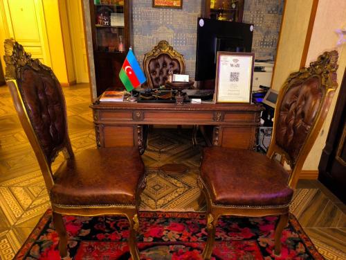 a desk with two chairs and a table with flags on it at Antique Royal Hotel in Baku