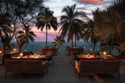 a restaurant with tables and chairs and a view of the ocean at Anantara Hua Hin Resort in Hua Hin