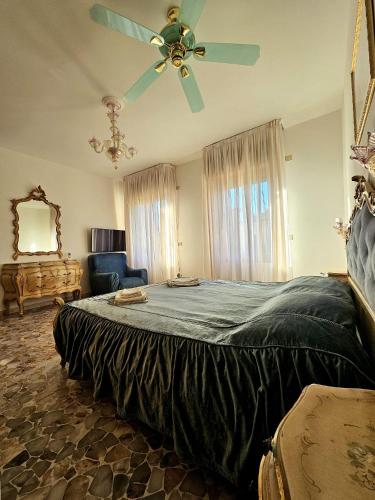 a bedroom with a large bed with a ceiling fan at Cà ARIVANLIAL Venice villa apartament in Venice-Lido