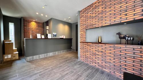 a lobby with a brick wall and a counter at FUKUOKA MOJIKO STAY x 完全非対面セルフチェックイン 門司港駅徒歩5分 in Kitakyushu