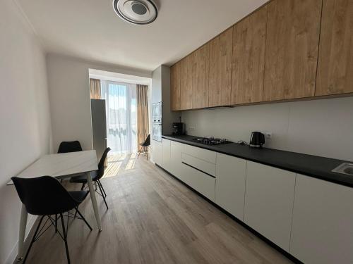 a kitchen with white cabinets and a table and chairs at White loft ЖК Престиж in Ternopilʼ