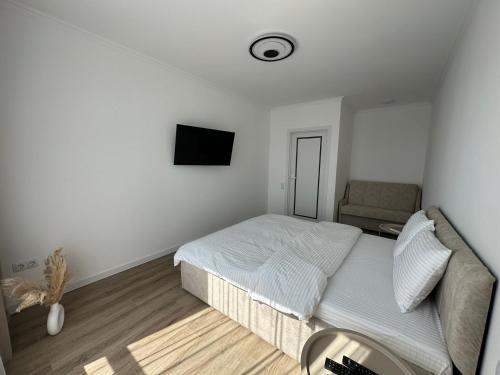 a white bedroom with a bed and a couch at White loft ЖК Престиж in Ternopilʼ