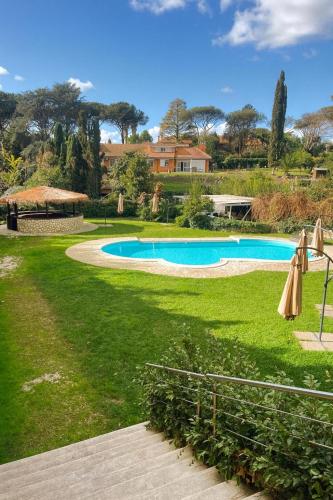 een zwembad in een tuin met parasols bij Villa Roma Open Space - Location per eventi 2 piscine riscaldate - in Rome
