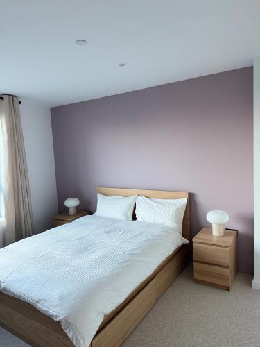 a bedroom with a large bed with white sheets at 02 Arena, Thames Riverside Retreat in London