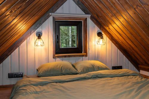 Metsamaja Põhja-Kõrvemaal : غرفة نوم بسرير مع نافذة واضاءة