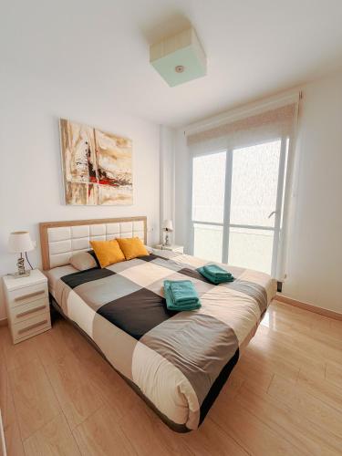 a bedroom with a large bed and a window at LaMata Apartament in La Mata