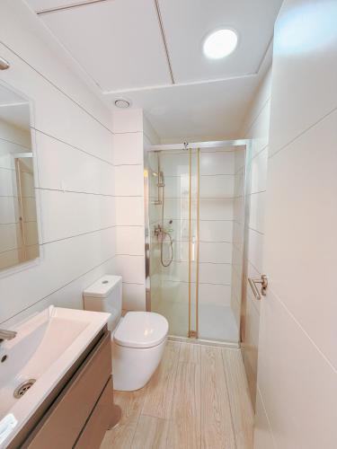 a white bathroom with a toilet and a shower at LaMata Apartament in La Mata