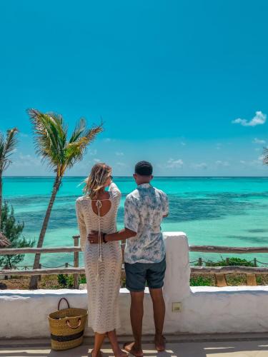 a man and a woman looking at the ocean at Kaskazi Hotel Zanzibar in Jambiani