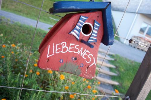 a red bird house with the words life beesyss at Hotel Dreiländerblick Dornbirn in Dornbirn