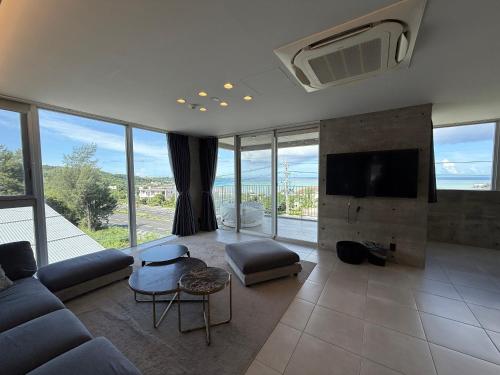 a living room with a couch and a tv at Emerald Ocean Villa in Onna
