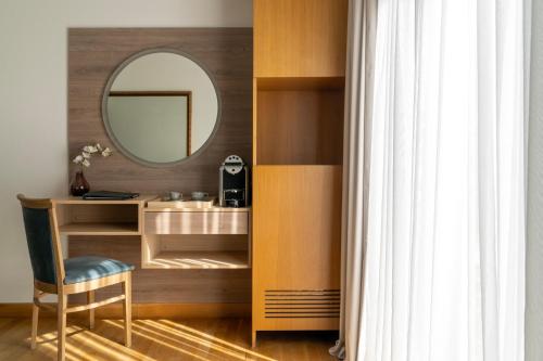 a dressing room with a mirror and a chair at Coral Hotel Athens in Athens