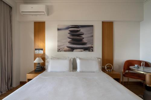 a bedroom with a bed with a stack of towels at Coral Hotel Athens in Athens