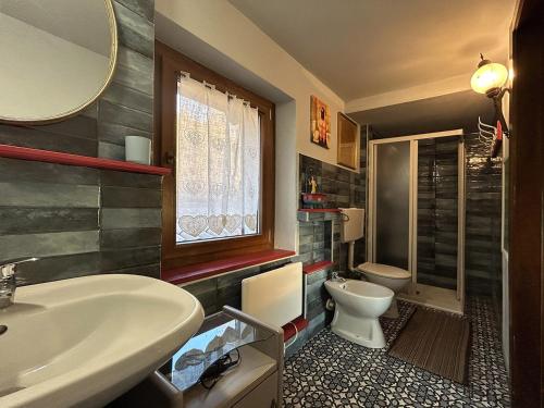 a bathroom with a tub and a toilet and a sink at Villa della Comare in Osigo