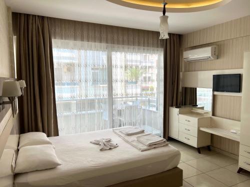 ein Schlafzimmer mit einem Bett und einem großen Fenster in der Unterkunft Cemal Bey Hotel in Alanya