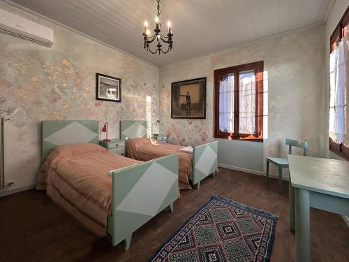 a bedroom with two beds and a table at Villa della Comare in Osigo