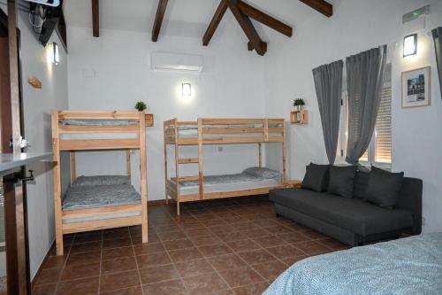 Habitación con cama, sofá y literas. en Albergue Turistico Municipal Santo Tomé, en Santo Tomé