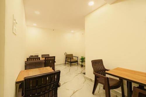 Un comedor con mesas y sillas de madera. en FabHotel VK's Gandimaisamma, en Hyderabad