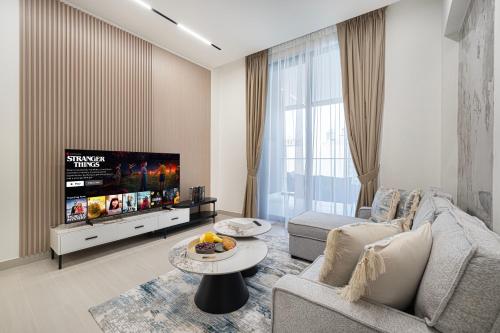 a living room with a couch and a tv at Elegant 2BR With Modern Design Near to Circle Mall in Dubai