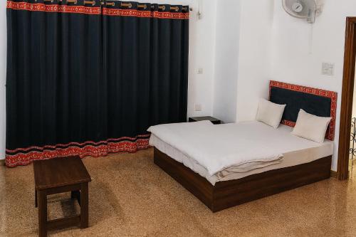 a bedroom with a bed and a black curtain at Stay Guru Resort Farm Villa in Bhuj