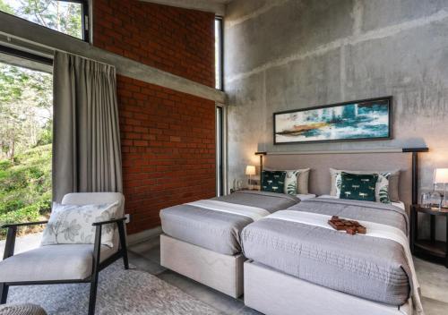 a bedroom with two beds and a brick wall at LohonoStays Amani Villa 10A in Coonoor