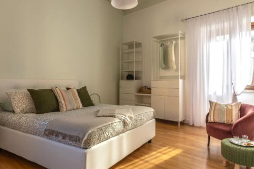a bedroom with a bed and a chair and a window at Maison 161 in Rieti
