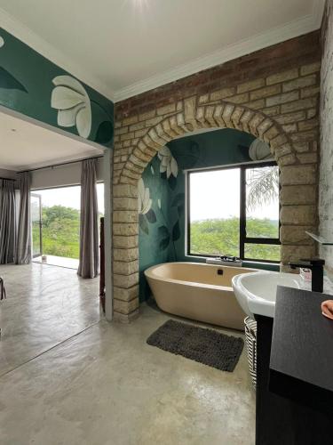 a bathroom with a large tub and a window at Hooggelegen Estate in White River