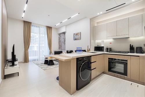 a large kitchen with a washer and a dishwasher at Elegant 2BR With Modern Design Near to Circle Mall in Dubai