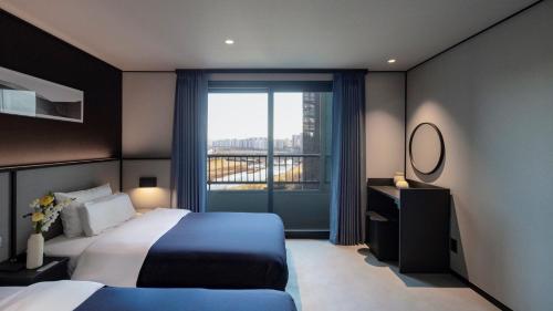 a bedroom with a bed and a large window at 대전 유성 낙원온천호텔 by 아늑 in Yusŏng