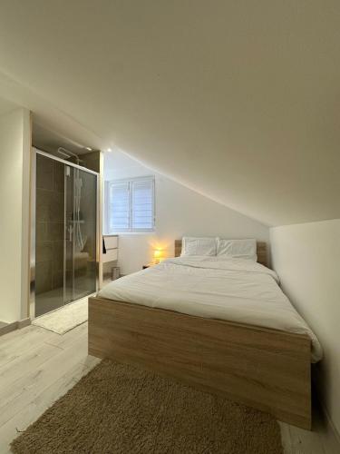 a bedroom with a bed and a glass shower at Appartement cosy 2 chambres in Jougne