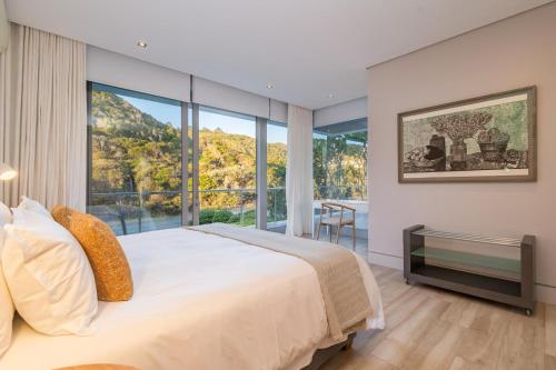 a bedroom with a large bed and a large window at Ocean View Villa - Keurboomstrand in Plettenberg Bay