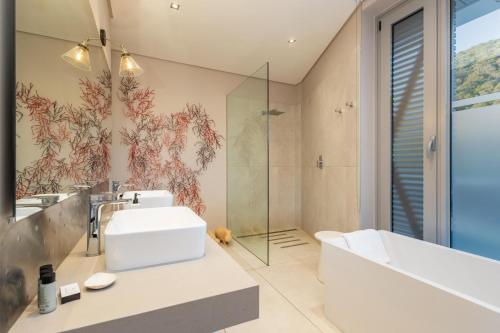 a bathroom with a sink and a tub and a shower at Ocean View Villa - Keurboomstrand in Plettenberg Bay