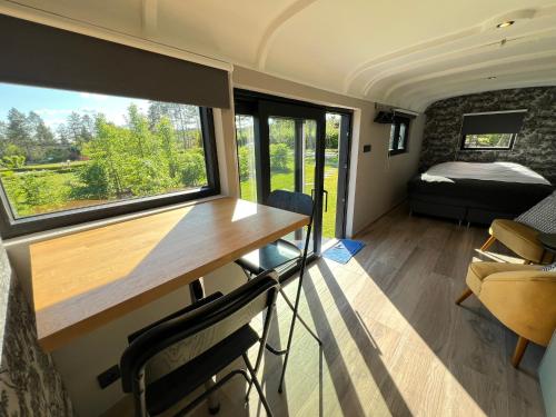 a train room with a table and a window at Pine Tree Tiny cottage in Rochefort
