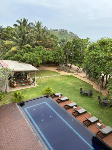 an aerial view of a swimming pool with chairs and tables at Villa Talay - 5 Bedroom Beachfront Villa in Talalla South