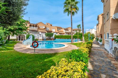 een zwembad met een bordje 'Niet zwemmen' in een tuin bij Casa Narú Albir, duplex appartement met ruim terras en buitenkeuken in Albir