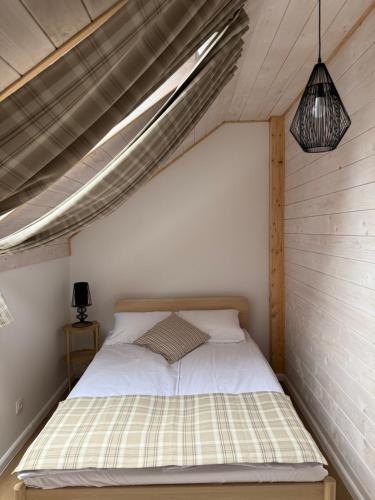 a bed in a small room with a ceiling at Mamma Mia Park in Łukęcin
