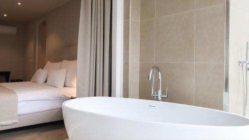 eine Badewanne im Bad mit einem Bett in der Unterkunft Dam Residence in Zaandam